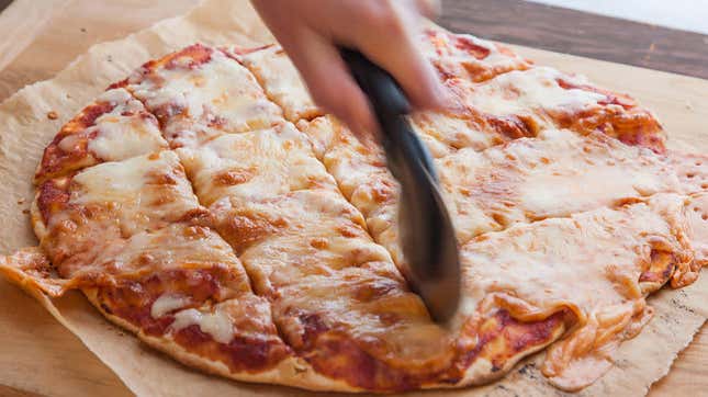 hand holding cutter for st louis style pizza
