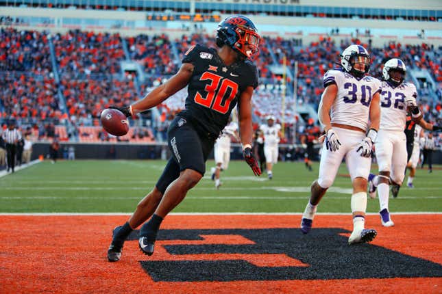 Running back Chuba Hubbard #30 of the Oklahoma State Cowboys scores on a 62-yard run against linebacker Garret Wallow #30 and defensive end Ochaun Mathis #32 of the TCU Horned Frogs on November 2, 2019 at Boone Pickens Stadium in Stillwater, Oklahoma. OSU won 34-27. 