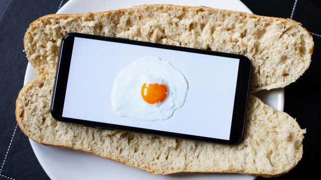 split baguette with cell phone on it displaying egg