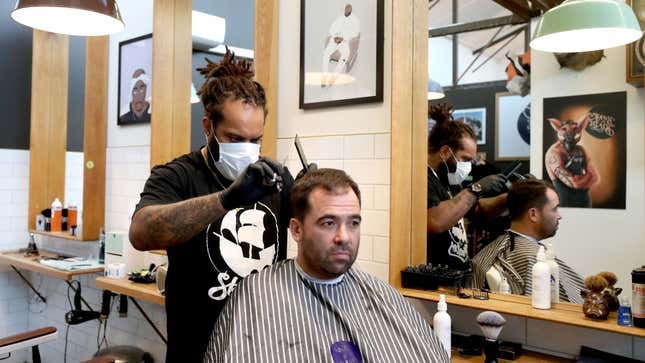 A barber wearing a face mask works on a customer’s hair at Board &amp; Blade  on May 14, 2020 in Auckland, New Zealand.