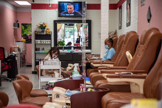 A worker paints a woman’s nails at a nail salon amid the coronavirus pandemic in Austin, Texas on May 8, 2020 following a slow reopening of the Texas economy.