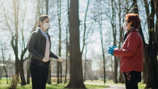 people talking in a park with masks 
