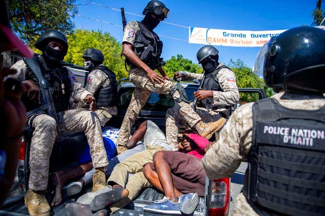 Police move detained demonstrators in the bed of a pick-up truck to a police station during a protest to demand the resignation of Haitian President Jovenel Moise in Port-au-Prince, Haiti, Sunday, Feb. 7, 2021. 