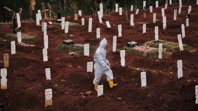 A municipal cemetery worker walks through a special cemetery for suspected covid-19 victims on September 11, 2020 in Jakarta, Indonesia