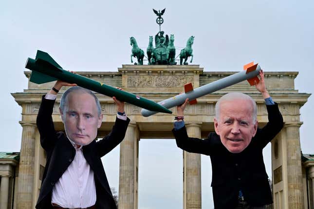 Peace activists wearing masks of Russian President Vladimir Putin (L) and President Joe Biden pose with mock nuclear missiles in front of Berlin’s landmark the Brandenburg Gate on January 29, 2021 in an action to call for more progress in nuclear disarmament.
