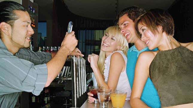 Image for article titled Of Course Busy Bartender Doesn’t Mind Taking Picture Of You And Your Friends