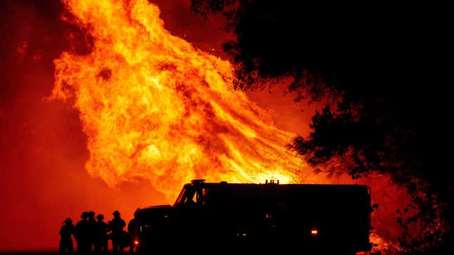 Butte county firefighters watch as flames tower over their truck at the Bear Fire in Oroville, California on Sept. 9, 2020. 