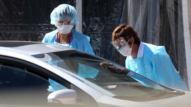 Medical personnel take a sample from a person at a drive-thru covid-19 testing station at a Kaiser Permanente facility on March 12, 2020 in San Francisco, California