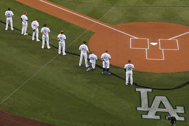 Mookie Betts #50 of the Los Angeles Dodgers kneels during the national anthem before the Opening Day game against the San Francisco Giants at Dodger Stadium on July 23, 2020 in Los Angeles, California. The 2020 season had been postponed since March due to the COVID-19 pandemic. 