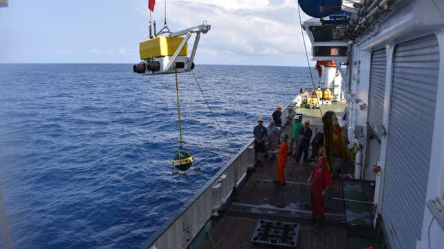 A seismometer being lifted near one of the survey sites.