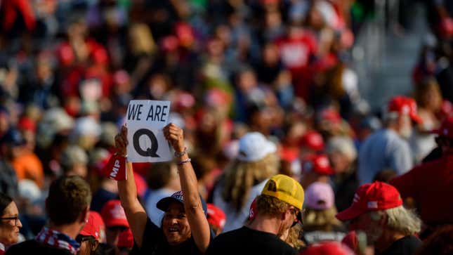 A woman holds up a QAnon sign to the media as attendees wait for President Donald Trump to speak at a campaign rally at Atlantic Aviation on September 22, 2020 in Moon Township, Pennsylvania. 