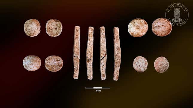 Several game chips (showing both sides of each) and a rare four-sided elongated dice (showing all four sides) found in the cremation pit. 