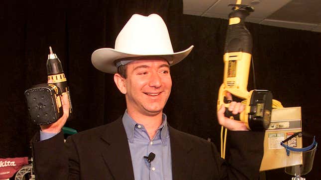 Jeff Bezos holds a cordless power drill and reciprocating saw at a New York press conference on November 9, 1999. 