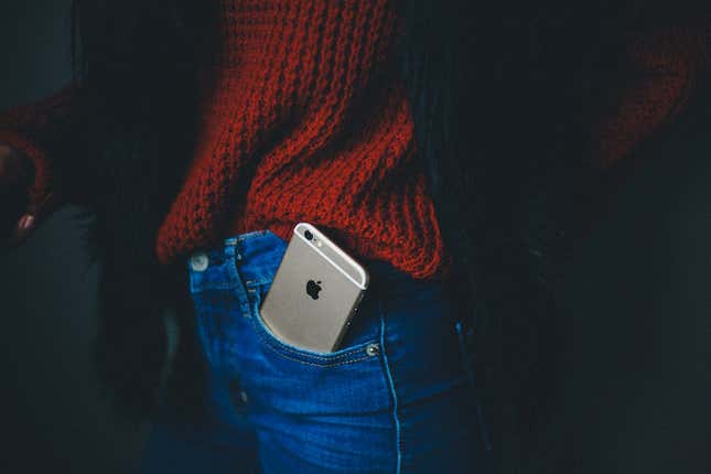 Un iPhone sobresaliendo del bolsillo del pantalón de una persona joven