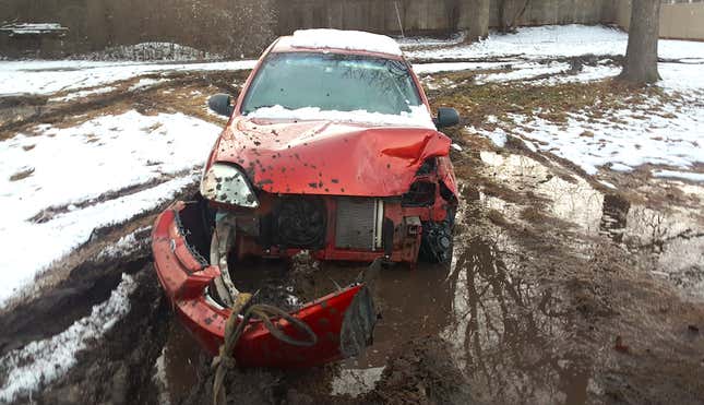Image for article titled You Haven't Reached Rock Bottom Until You've Got A Totaled Kia Rio Stuck In Your Backyard