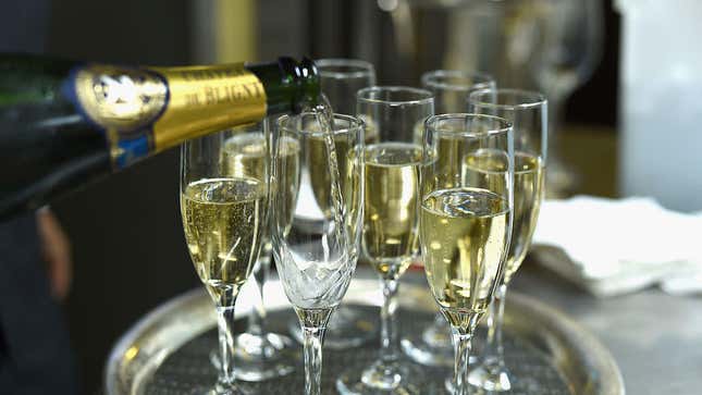 Champagne being poured into flutes on a silver tray