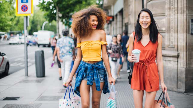 Two girls with shopping bags on a city street