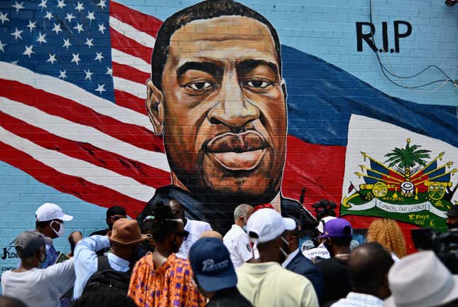 People gather at the unveiling of artist Kenny Altidor’s memorial portrait of George Floyd painted on a storefront sidewall of CTown Supermarket on July 13, 2020 in Brooklyn, New York. 