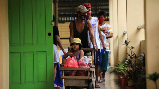 Residents carrying their belongings arrive at an evacuation center in Legaspi, Albay province, south of Manila on October 31, 2020, ahead of Typhoon Goni’s landfall.