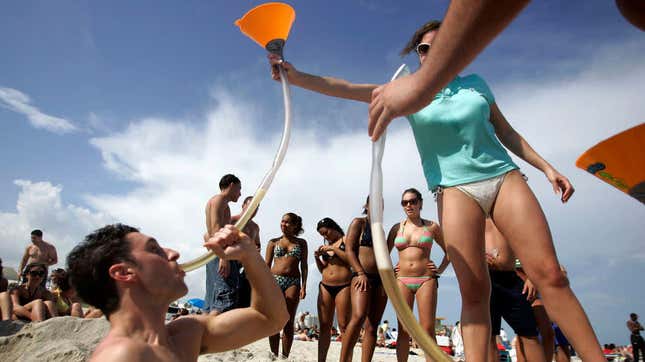College student bonging beer on the beach