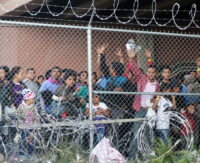 In this March 27, 2019, file photo, Central American migrants wait for food in a pen erected by U.S. Customs and Border Protection to process a surge of migrant families and unaccompanied minors in El Paso, Texas. 