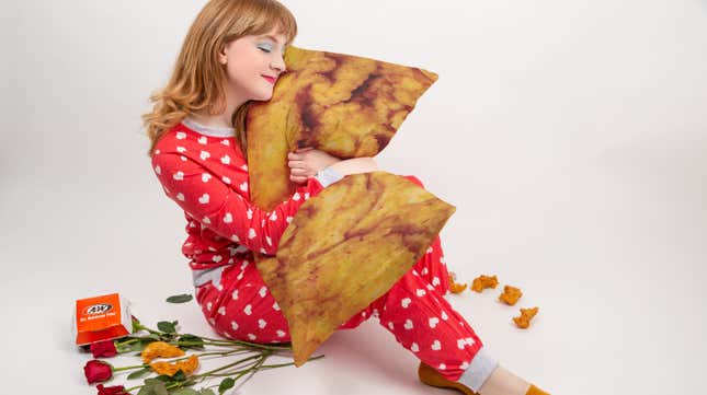 Woman in heart pajamas hugs fried chicken body pillow