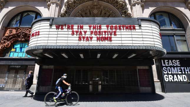A cyclist wearing a face mask rides past the Million Dollar Theater, closed due to the coronavirus pandemic, in Los Angeles, California on May 4. 