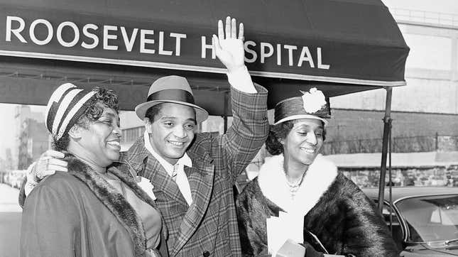 Rock and Roll singer Jackie Wilson waves as he leaves New York’s Roosevelt Hospital with his mother Elizabeth Lee, left, and his then-wife Friea Wilson on March 18, 1961.