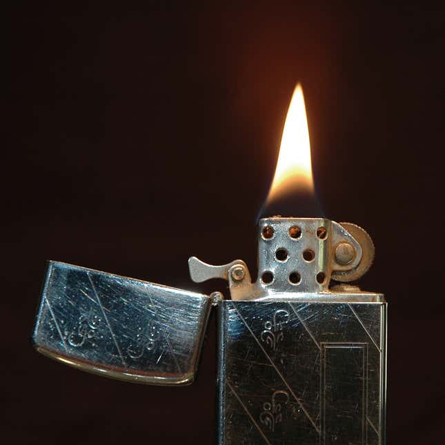 A lit 1968 slim model Zippo.