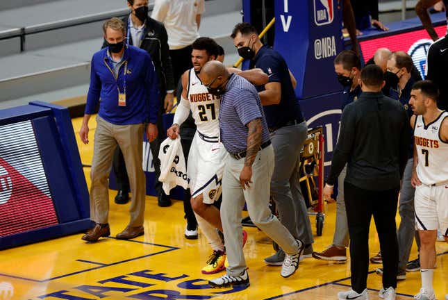 Jamal Murray #27 of the Denver Nuggets is helped off the court after an injury in their game against the Golden State Warriors at Chase Center on April 12, 2021 in San Francisco, California. 