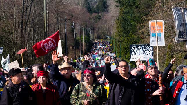 Tseil Waututh Chief Reuben George (second from right) raises a fist while leading a protest against Kinder Morgan’s Trans Mountain Pipeline expansion.
