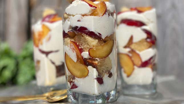 Three glasses of layered Plum Trifle beside a golden spoon
