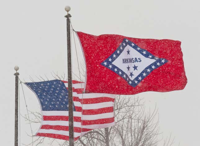 In a February 2011 file photo, the U.S. and Arkansas flags blow in the wind in Fayetteville, Ark. Arkansas has decided to remove two Confederate-era statues representing it in Statuary Hall, but the state still has refused to change the meaning of a star on the state’s flag that currently represents the Confederacy.