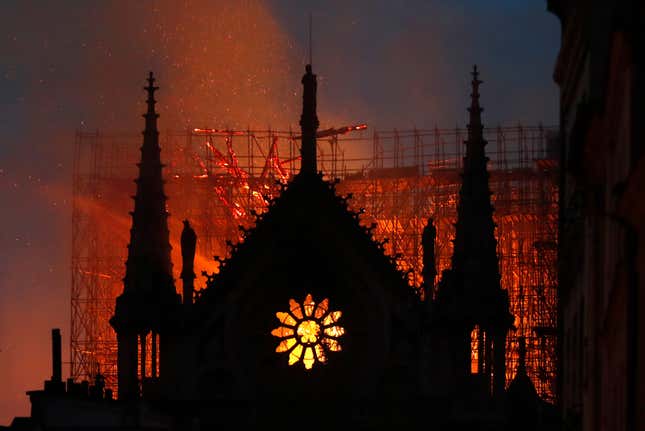 The glow of flames can be seen through the windows of Notre Dame as fire ravaged the centuries-old cathedral in Paris April 15, 2019.