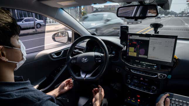 A safety driver sits behind the wheel of a self-driving taxi in South Korea.