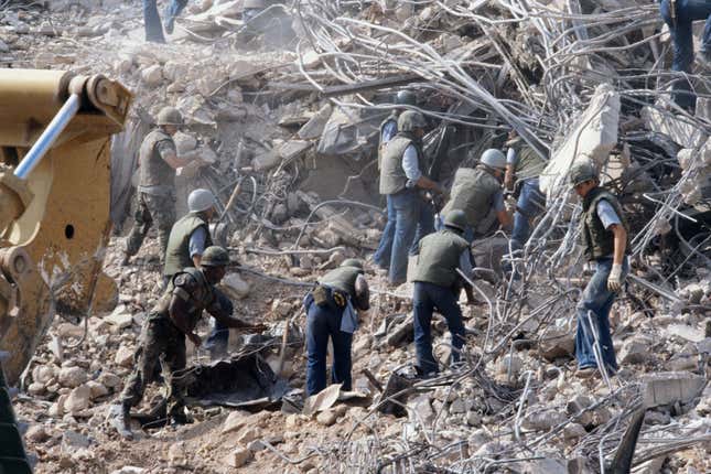 American Marines search for survivors and bodies in the rubble, all that was left of their barracks head quarters in Beirut, after a terrorist suicide car bomb was driven into the building and detonated, killing 241 US servicemen and wounding over 60.