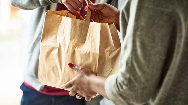 person handing shopping bag to other person