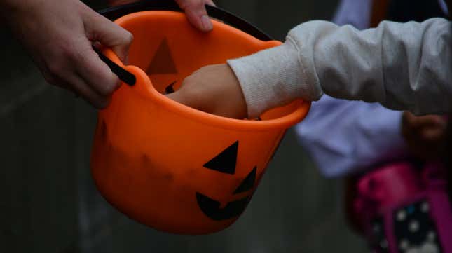  Hands Picking Candy From Halloween Basket 