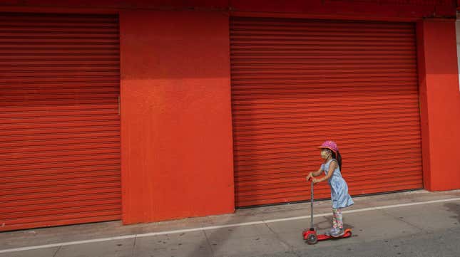 A child rides a scooter through Venice, California in late April 2020. 