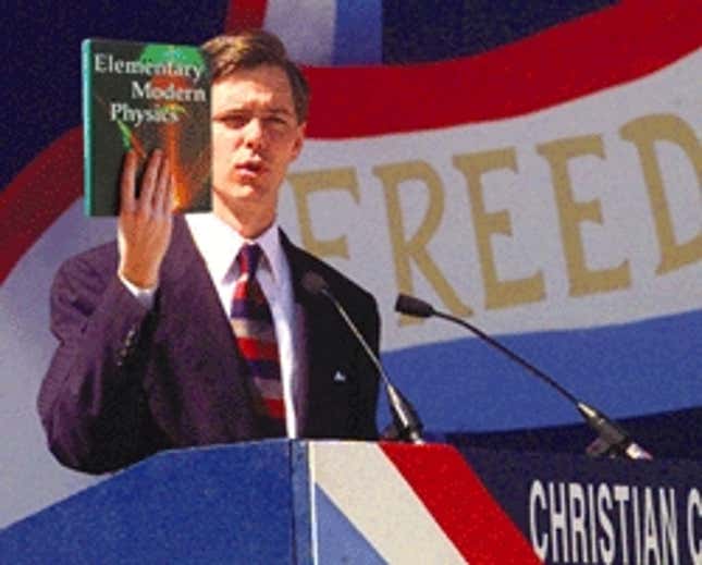 Christian Coalition president Ralph Reed holds a textbook he claims is being used to teach physics in schools.