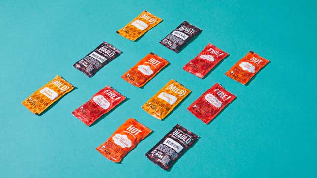 Taco Bell hot sauce packets against blue background [image provided by Taco Bell]