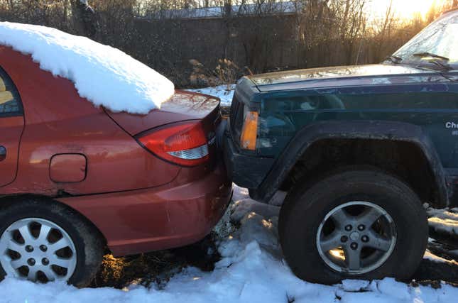 Image for article titled You Haven't Reached Rock Bottom Until You've Got A Totaled Kia Rio Stuck In Your Backyard