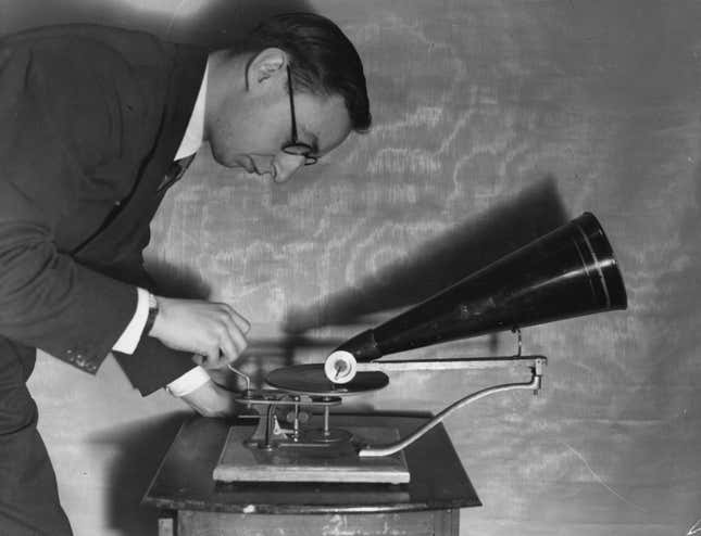 Circa 1897: A man operating an early Gramophone from the Gramophone & Typewriter Company.