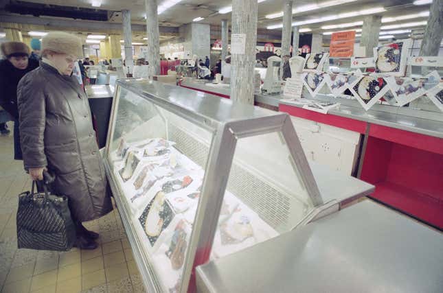 A Soviet woman stares at rows of empty refrigerators used for storing milk, instead the refrigerators are used to display plastic shopping bags at a local supermarket in Moscow on Tuesday, Nov. 27, 1990.