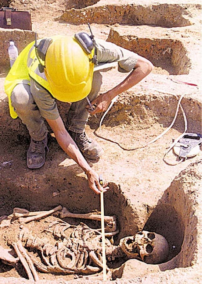 An archaeologist examines the intact remains of a spooky “skeleton person.”