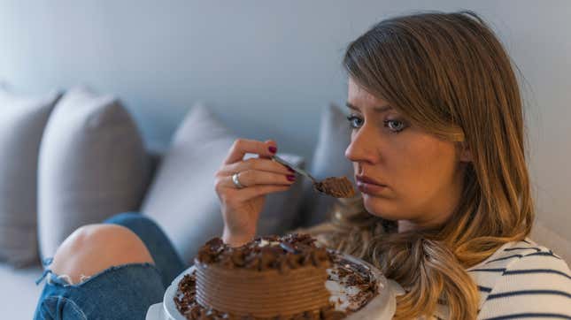 Titled in the stock image library as “Depressed Woman Eats Cake”