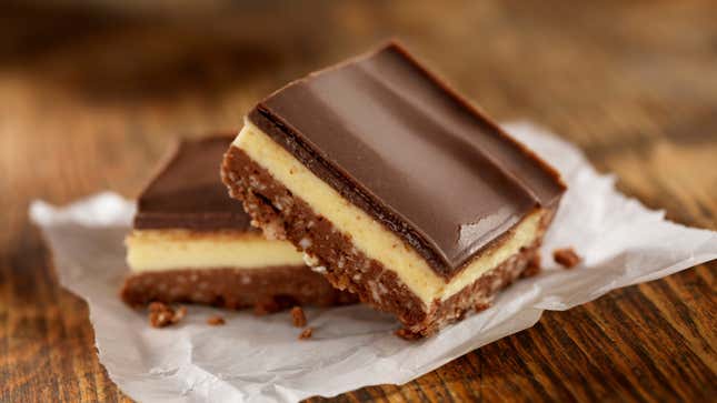 Nanaimo Bars have a crumb and coconut base layer, topped with vanilla custard butter icing and covered in chocolate