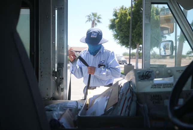 A USPS postal worker wears a face mask amid the COVID-19 pandemic in hard-hit Imperial County on July 21, 2020, in El Centro, California. Imperial County currently suffers from the highest death rate and near-highest infection rate from COVID-19 in California.