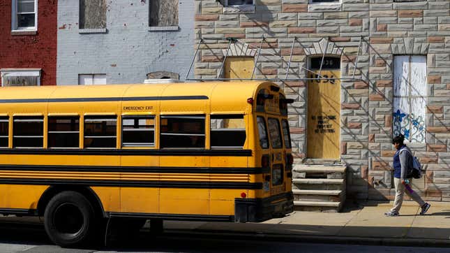 A student walks past vacant row houses to a waiting school bus as school gets out for the day in Baltimore (April 9, 2013)