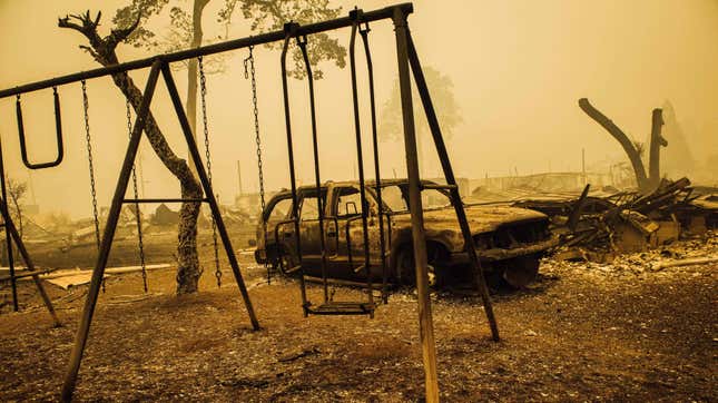 A charred swing set and car are seen after the passage of the Santiam Fire in Gates, Oregon, on September 10, 2020.